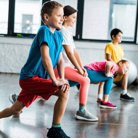 Djeca vježbaju i istežu se u sportskoj dvorani na treningu sportske škole Sportanci